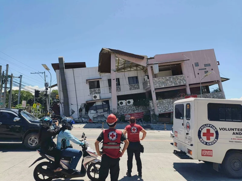 Philippine Red Cross responders outside damaged building